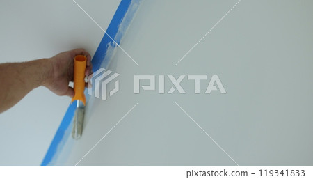 Man worker hand painting the wall inside the house and building. Builder, tools, apartment renovation. 119341833