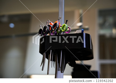 Scissors and styling tools organized in a salon workspace at midday Scissors and styling tools organized in a salon workspace at midday 119342202