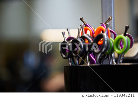 Colorful scissors in a hair salon, ready for a stylish haircut session 119342211