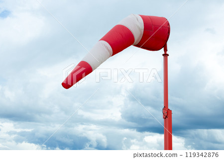 Red and white weather vane and dramatic cloudy sky. Red and white weather vane and dramatic cloudy sky. 119342876