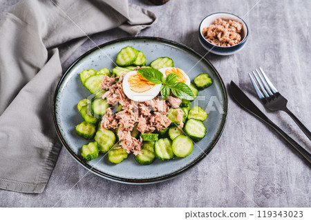 Keto salad with tuna, cucumber, egg and basil in a bowl on the table 119343023
