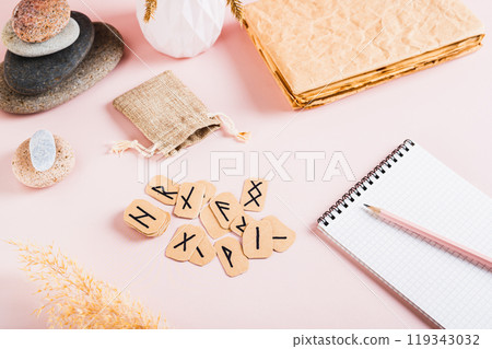 Cardboard Scandinavian runes for fortune telling on a pink background Cardboard Scandinavian runes for fortune telling on a pink background 119343032