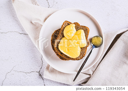 Close up of sandwiches on grain bread with honey butter on a plate on the table top view Close up of sandwiches on grain bread with honey butter on a plate on the table top view 119343054