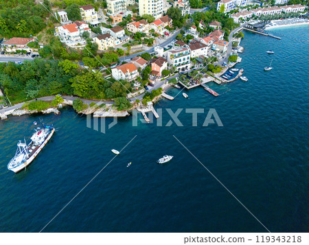 A small coastal village with piers where boats and a small ship are moored. View from a drone 119343218