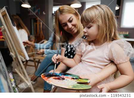 A mother and daughter enjoying a creative painting session at an art studio 119343231