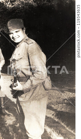 Photo of a young cadet in military uniform. A young man holds an anti-tank machine gun of the Kalashnikov system in his hands. Photo of a young cadet in military uniform. A young man holds an anti-tank machine gun of the Kalashnikov system in his hands. 119343635