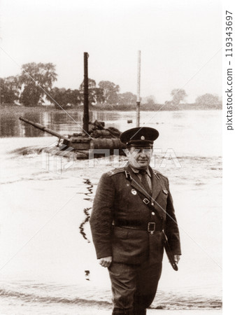 Photo of a lieutenant colonel of the Soviet army at military tank exercises. Tank T64 overcomes the water barrier. The tank rides along the bottom of the river. 119343697