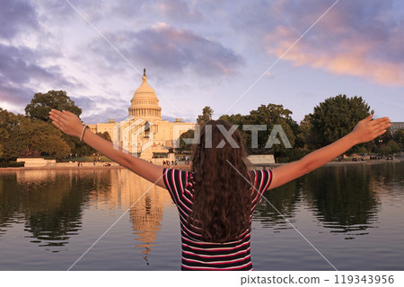 Teenager girl tourist admiring the US Capitol at sunset in Washington DC with nice reflection on the water, USA 119343956