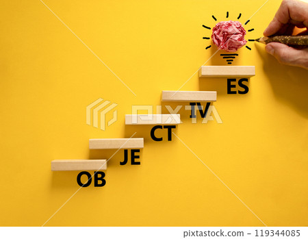 Objectives symbol. Concept word Objectives on beautiful wooden blocks. Beautiful yellow background. Businessman hand. Beautiful light bulb icon. Business objectives concept. Copy space. Objectives symbol. Concept word Objectives on beautiful wooden blocks. Beautiful yellow background. Businessman hand. Beautiful light bulb icon. Business objectives concept. Copy space. 119344085
