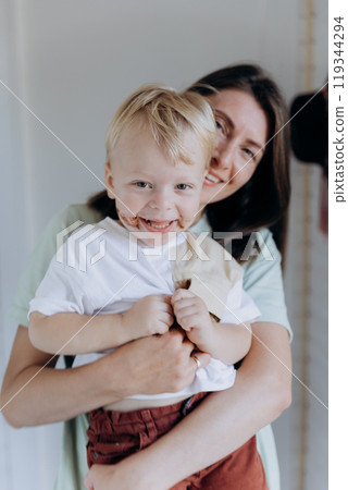 Mother and son smiling, sharing a joyful moment indoors, creating a warm family connection 119344294