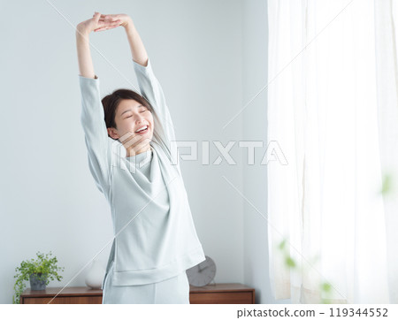 早上穿著睡衣伸展身體的女人 119344552