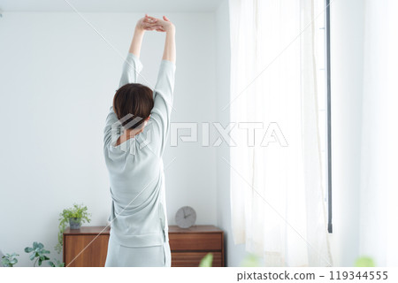 Woman stretching in pajamas in the morning 119344555
