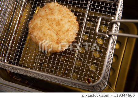 Fried cutlet in fryer basket 119344660