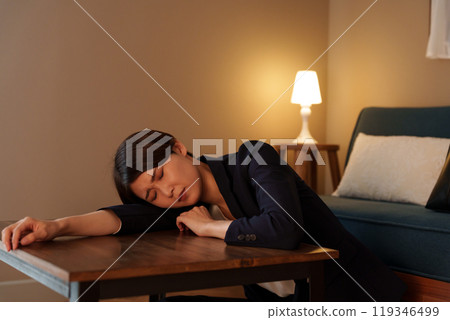 A woman who is tired from work and sleeps in the living room in her suit 119346499