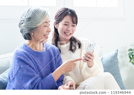 Grandson teaching grandma how to use a smartphone Grandson teaching grandma how to use a smartphone 119346944