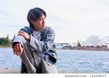 A Japanese man relaxing in front of the Sydney Opera House 119346977