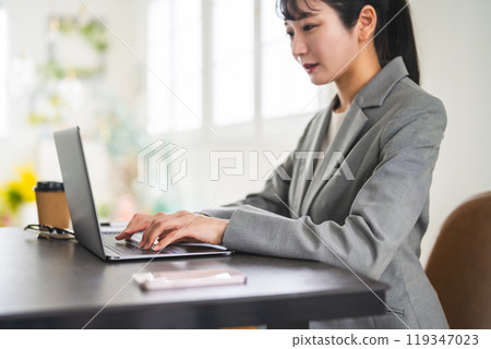 Business woman working on a personal computer 119347023