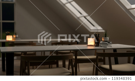 A close-up of a table with armchairs in a contemporary co-working space at night. 119348391