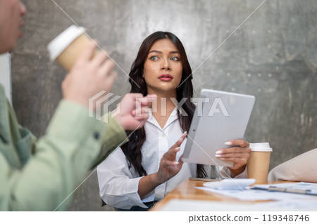 A gorgeous Asian businesswoman is focused on listening to her colleague's ideas in the meeting. A gorgeous Asian businesswoman is focused on listening to her colleague's ideas in the meeting. 119348746