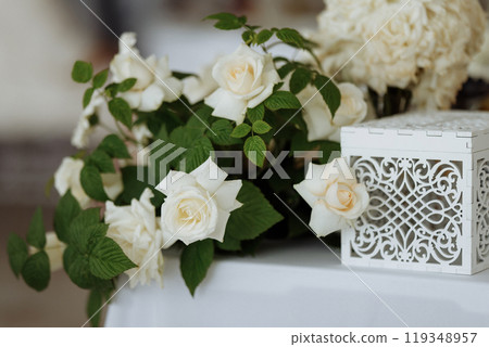 A white box with a floral design sits on a table A white box with a floral design sits on a table 119348957