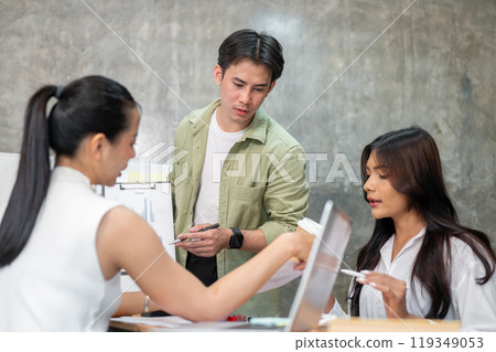 A professional, serious Asian businessman is having a meeting with his team. A professional, serious Asian businessman is having a meeting with his team. 119349053