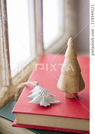 Old books and Christmas accessories placed on an antique windowsill 119349121