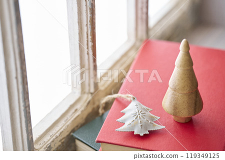 Old books and Christmas accessories placed on an antique windowsill 119349125