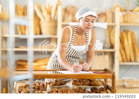 Woman seller signing document in bakery 119349203