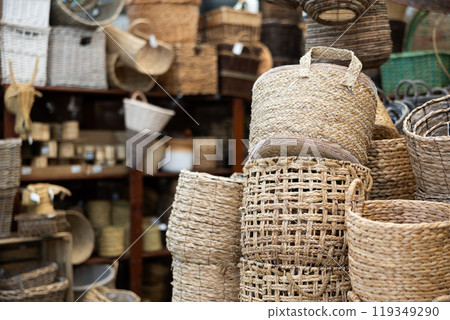 Stack pile of wicker baskets, large and small, stand on top of each other in store 119349290