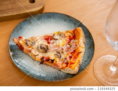 Piece of pizza with mushrooms and tomato served on a plate Piece of pizza with mushrooms and tomato served on a plate 119349325