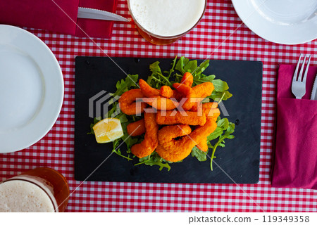 Sepia in a batter of tempera flour with lemon and arugula 119349358