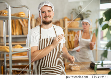 In bakery, confused male employee during quarrel with girl boss 119349462