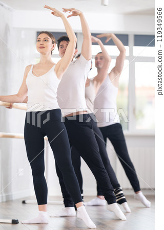 Group of dancers doing batman tandu jete at barre Group of dancers doing batman tandu jete at barre 119349566