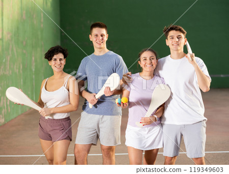 Two happy couples after playing paleta fronton on tennis court 119349603