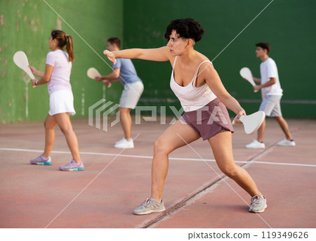 Portrait of sporty girl playing paleta fronton on outdoor court, ready to hit ball. Healthy and active lifestyle concept 119349626