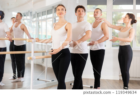 Group practicing ballet positions at barre with female instructor Group practicing ballet positions at barre with female instructor 119349634