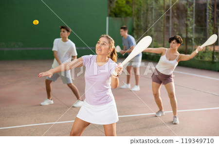 Woman Basque pelota player hitting ball with wooden racket 119349710