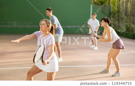 Sportive woman in shorts and t-shirt playing frontenis on court 119349755
