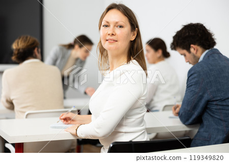 Focused adult female student sitting in college class 119349820