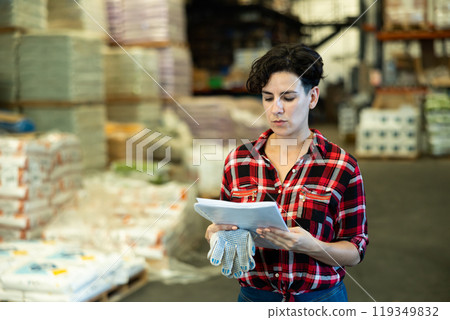 Woman checking documentation in warehouse Woman checking documentation in warehouse 119349832