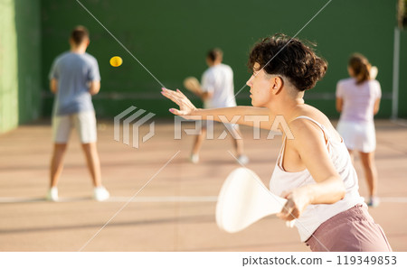 Woman playing Basque pelota on outdoor pelota court 119349853