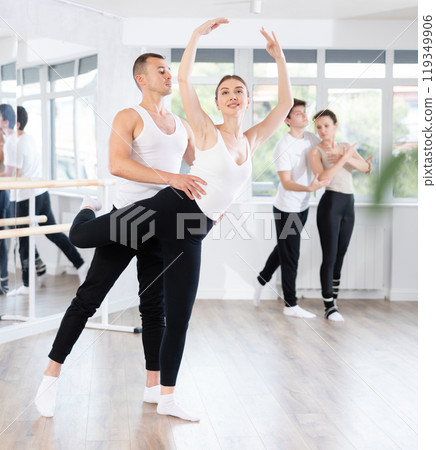 Ballet partners mastering paired technique at group class in studio 119349906