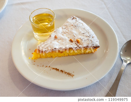 Piece of almond cake Tarta de Santiago with wine glass 119349975