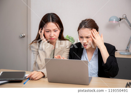 Two businesswoman stress and frustrated while working on laptop computer in office. 119350491