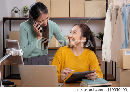 Two young asian woman working on tablet while managing and planning online business. 119350493
