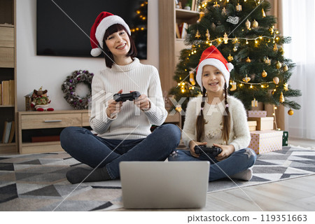 Mother and daughter enjoying Christmas video games together 119351663