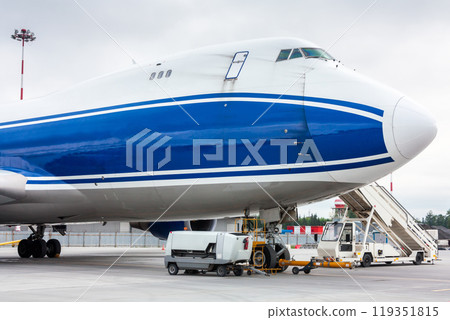 The front of wide body cargo transport airplane with towbar and passenger step near The front of wide body cargo transport airplane with towbar and passenger step near 119351815