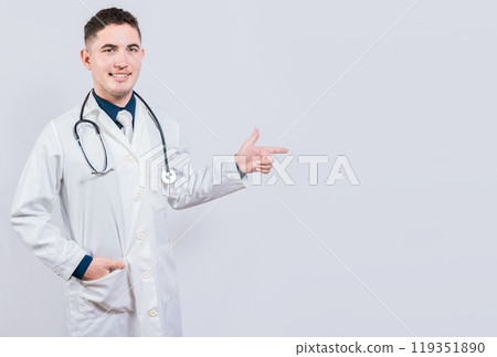 Handsome doctor pointing a promotion with finger. Latin doctor pointing at advertising space isolated. Happy doctor pointing right with finger Handsome doctor pointing a promotion with finger. Latin doctor pointing at advertising space isolated. Happy doctor pointing right with finger 119351890