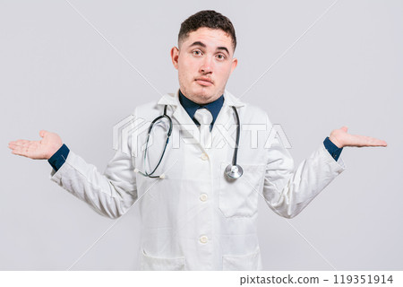 Puzzled doctor with open hands. Doubtful young doctor with open hands isolated. Insecure doctor concept isolated 119351914