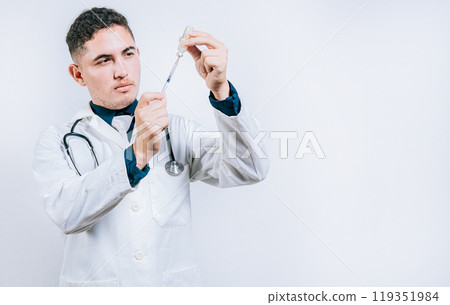 Handsome doctor drawing medicine from a vial with copy space. doctor drawing medicine from a vial. Concept of doctor with disease antidote Handsome doctor drawing medicine from a vial with copy space. doctor drawing medicine from a vial. Concept of doctor with disease antidote 119351984